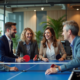 Groupe de collègues riant après une partie de ping-pong en bureau